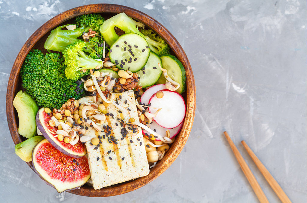 buddha bowl with tofu broccoli and vegetables in a wooden bowl. vegan healthy food concept.